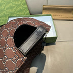 Brown Gucci baseball cap with GG-style monogram pattern and black adjustable strap.
