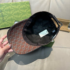 Brown Gucci baseball cap with GG-style monogram exterior and black inner lining.