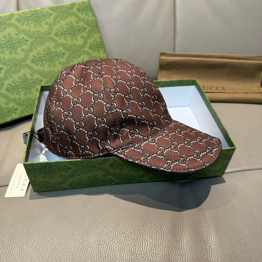 Brown Gucci baseball cap with GG-style monogram pattern, angled view on display box.