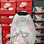 White sneaker heel with pink lining and laces, showing textured upper and collar