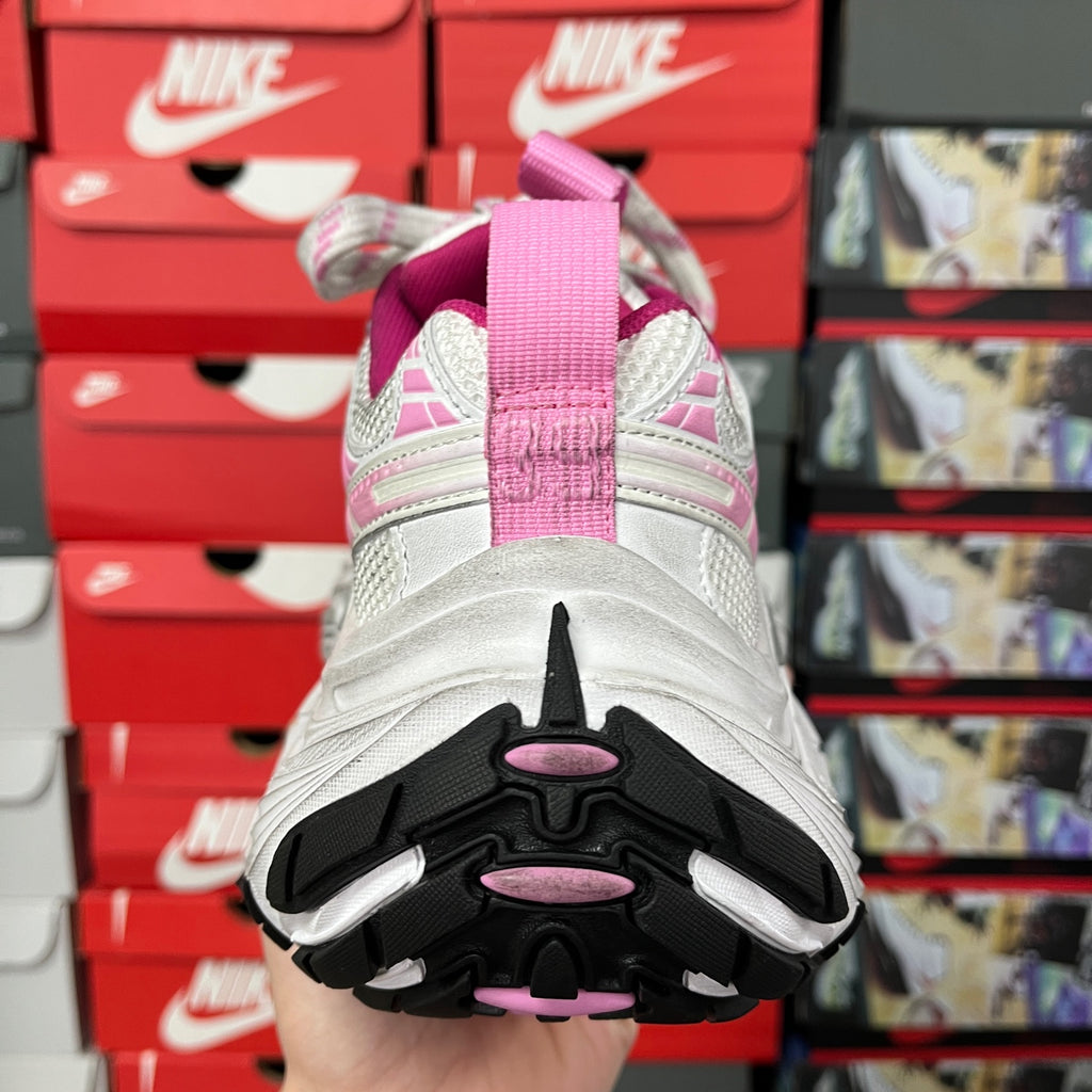 Rear view of white sneakers with pink accents and black outsole tread