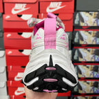 Rear view of white sneakers with pink accents and black outsole tread