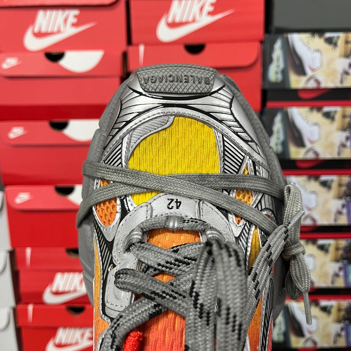 Red, yellow and orange panel sneaker close-up with gray laces and textured toe