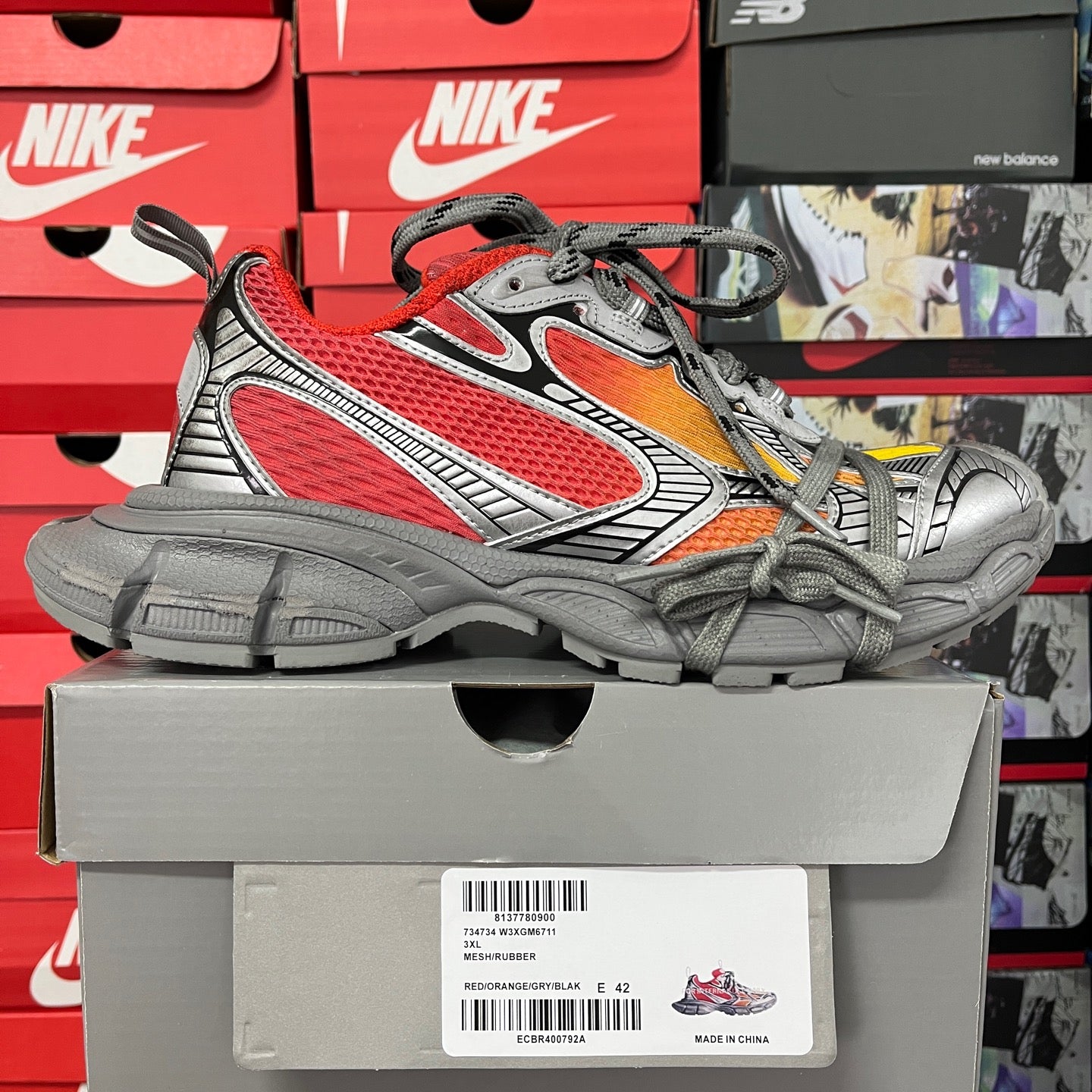Red and gray mesh sneaker with orange lining, gray laces, and chunky sole