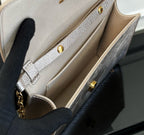 Beige interior compartment of a textured crossbody bag with gold snap hardware