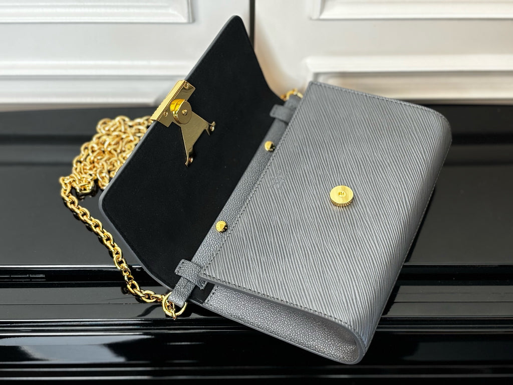 Louis Vuitton crossbody bag with light blue-gray front flap and dark interior lining