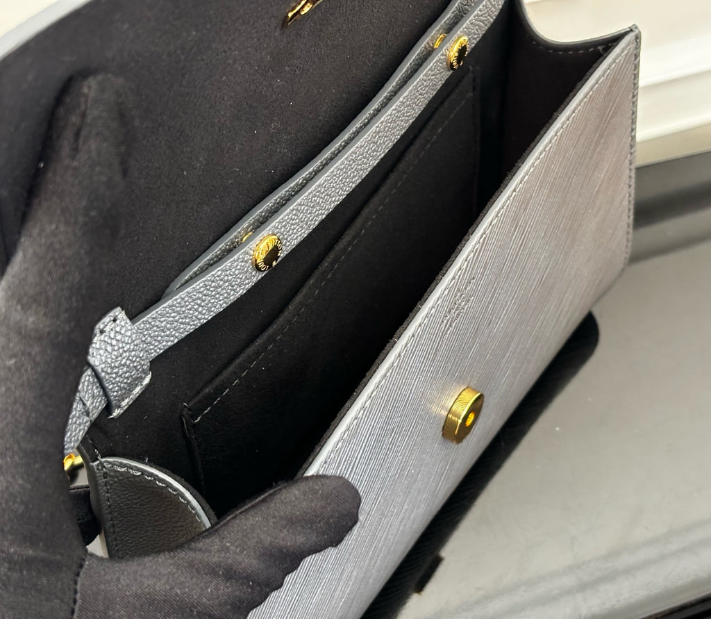 Louis Vuitton bag interior with black lining and small gold snap details