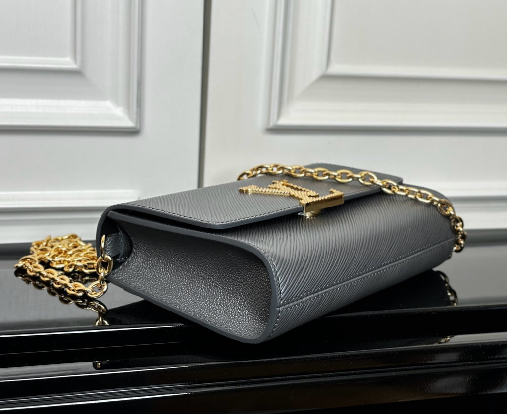 Louis Vuitton flap crossbody bag in light blue-gray, side view with gold chain strap