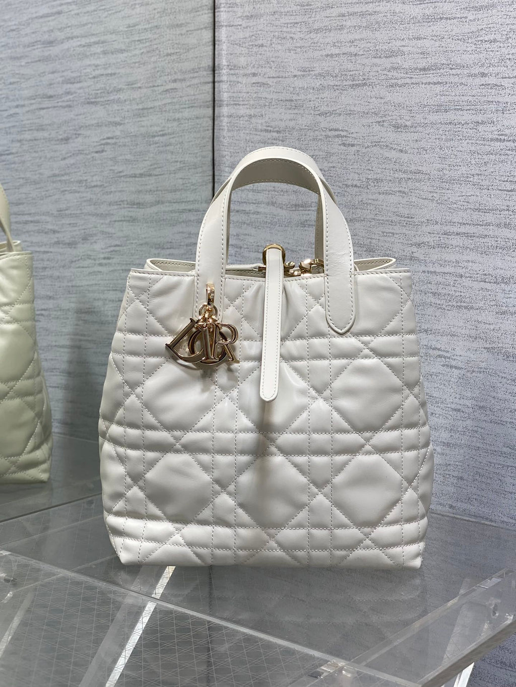 Dior quilted white tote bag with top handles and gold charm detail