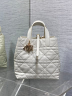 Dior quilted white tote bag with top handles and gold charm detail