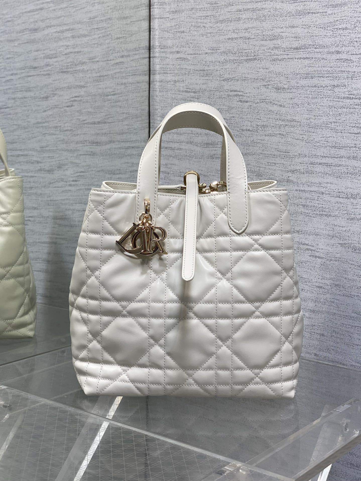 Dior quilted white tote bag with top handles and gold charm detail