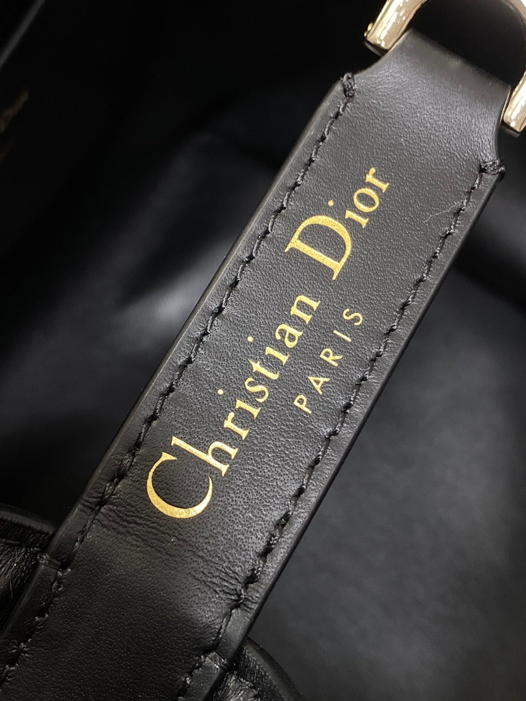 Dior 'Christian Dior Paris' text on black leather strap edge