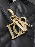 Dior gold-tone hardware charm on black quilted leather bag