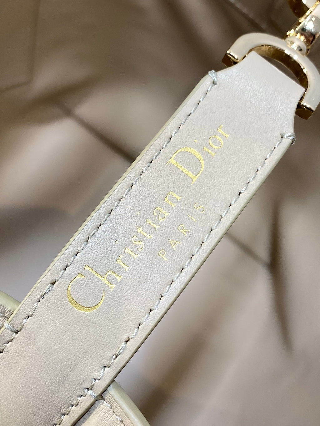 Dior cream leather label with “Christian Dior” text and stitched edge detail