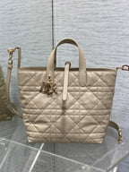 Dior cream quilted tote with top handles, front emblem charm, and detachable shoulder strap