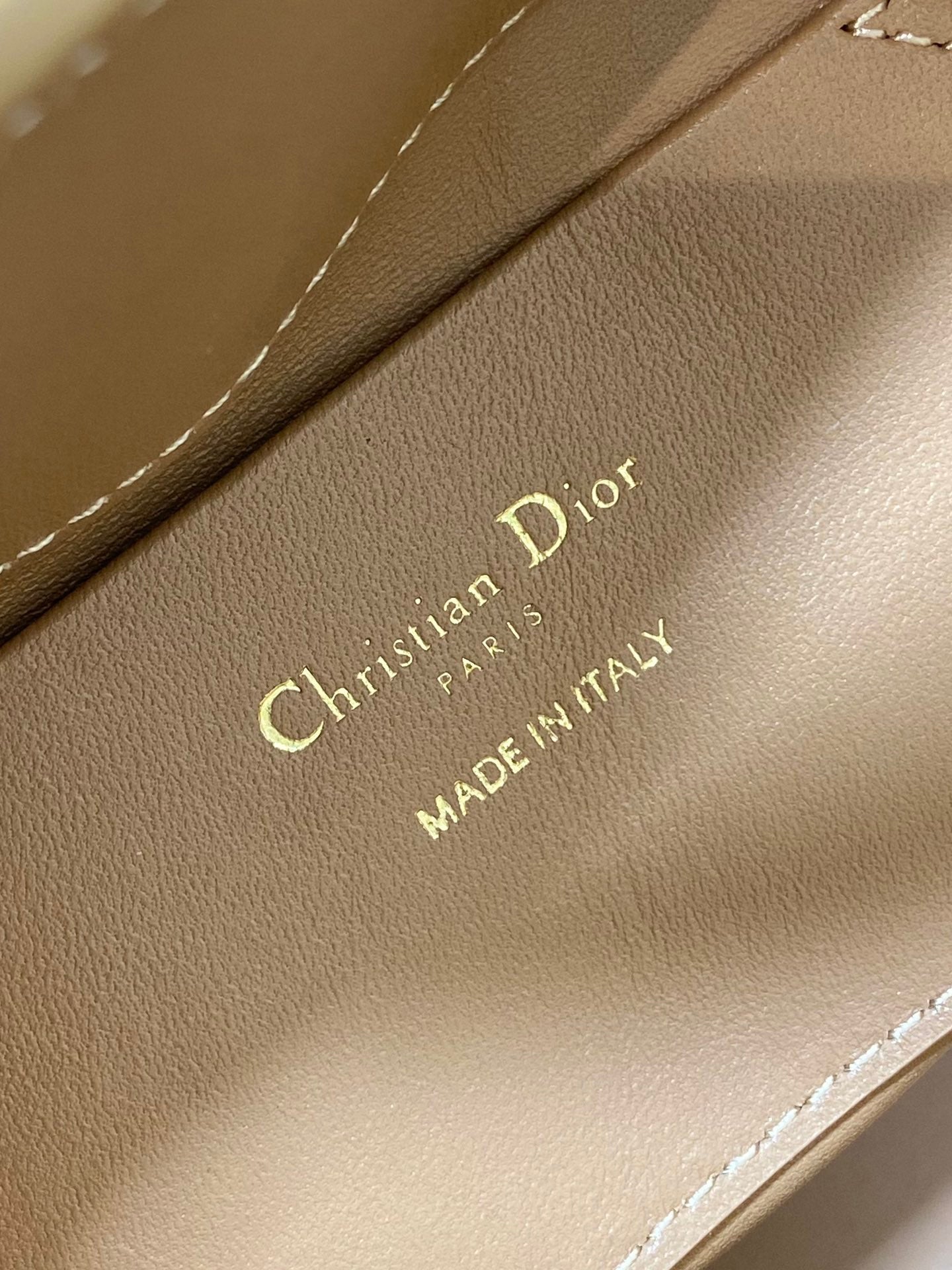 Beige Dior branding on leather strap: 'Christian Dior Paris, Made in Italy'