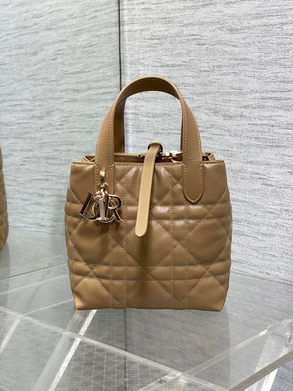 Dior quilted mini handbag in beige with top handles and gold-tone logo charm