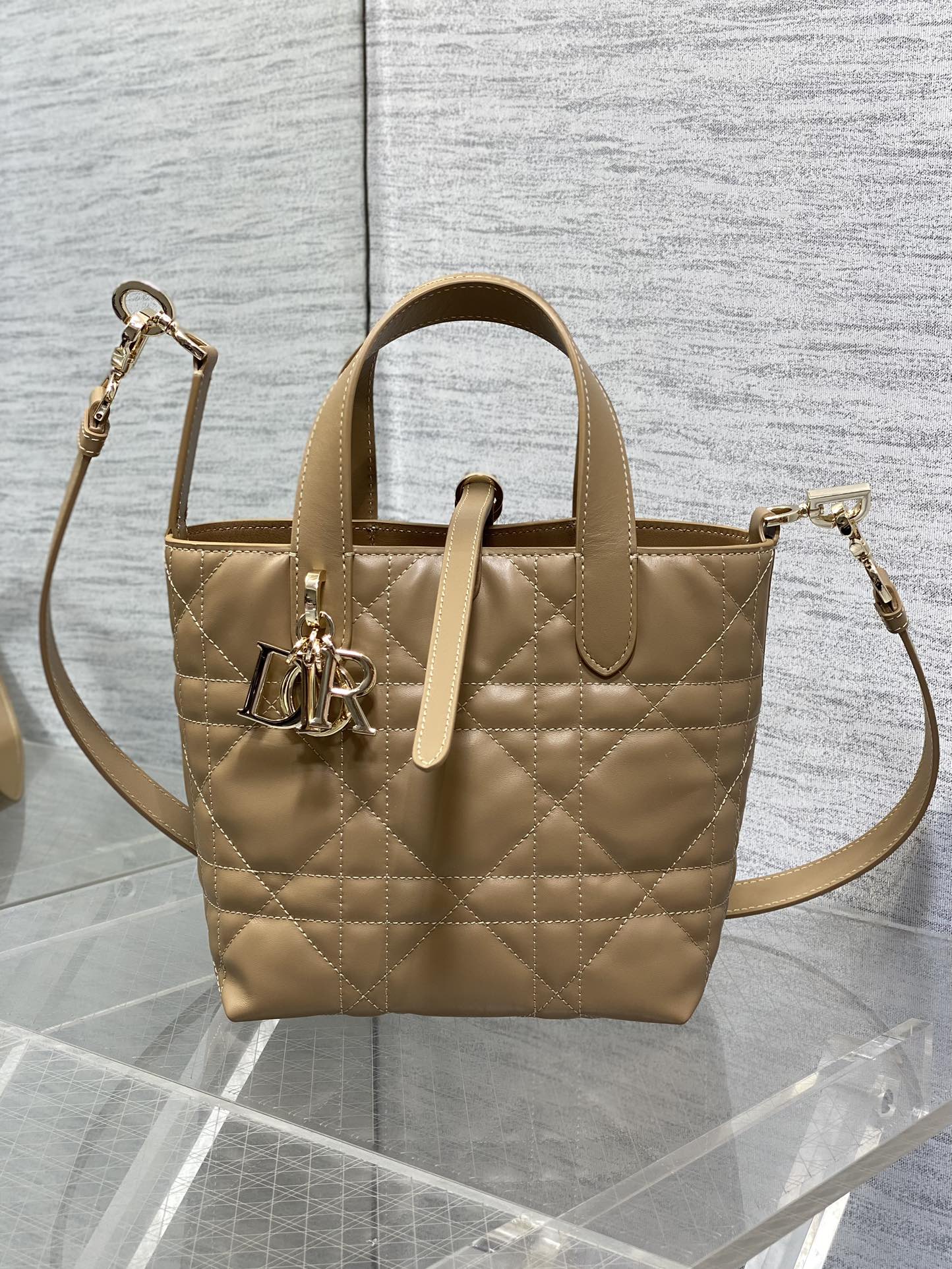 Dior quilted mini handbag with adjustable shoulder strap and gold-tone logo charm