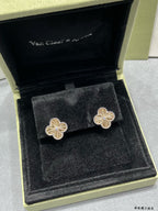 Gold-tone clover flower stud earrings, set shown in black box.
