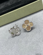 Silver-tone clover flower stud earrings and a silver ring with green stone.
