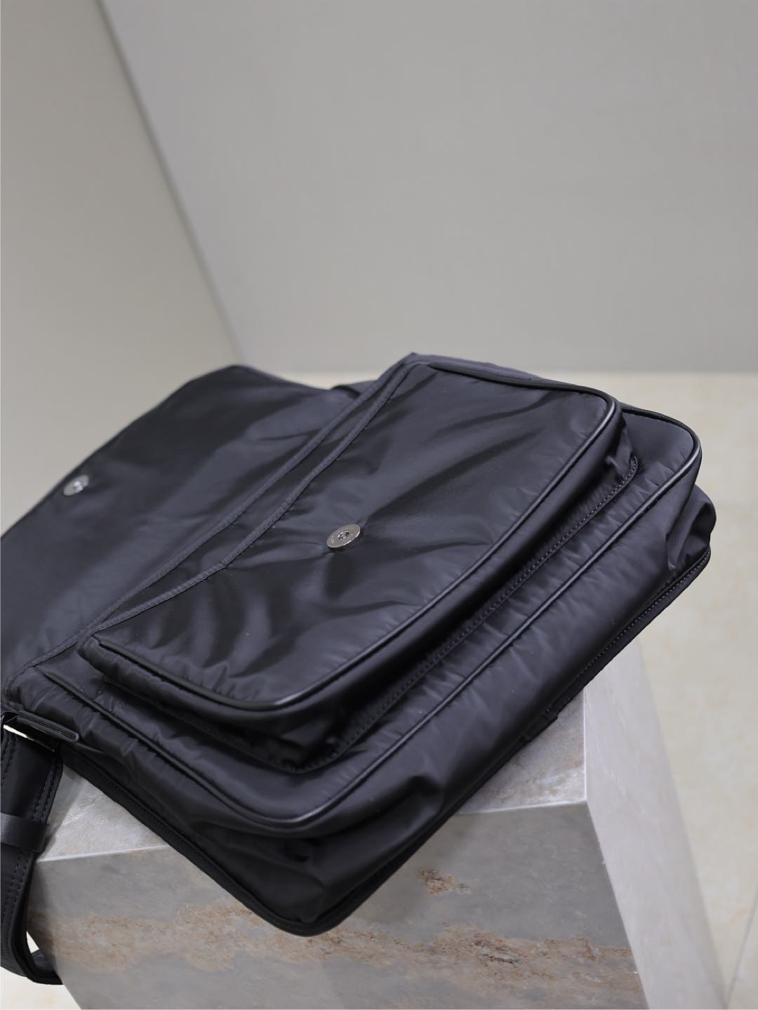 YSL bag with front flap open, interior pocket and snap detail, dark nylon