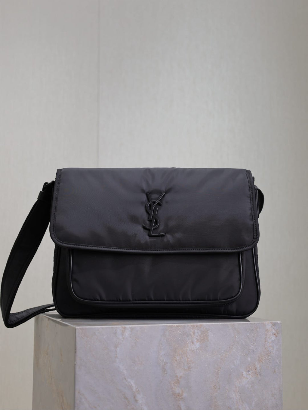 YSL bag with front flap and YSL logo, dark padded fabric, shoulder strap