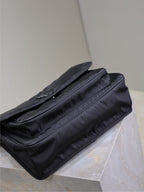 YSL bag rear view with flap pocket and stitching details, dark nylon shoulder strap