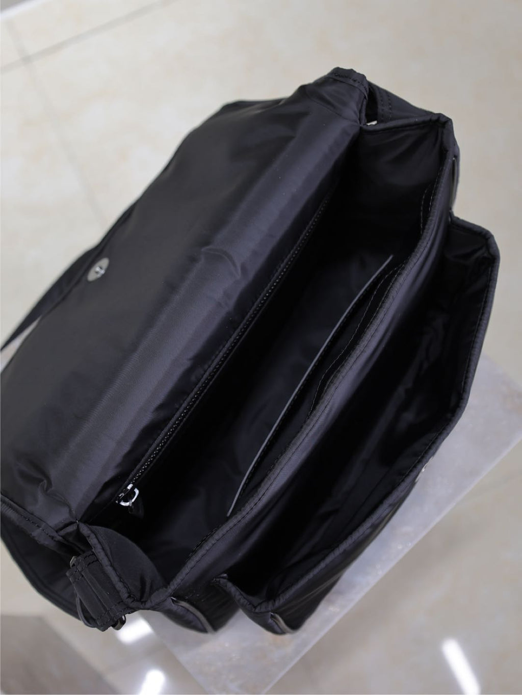 YSL bag open view showing interior lining and zip closure, dark padded fabric