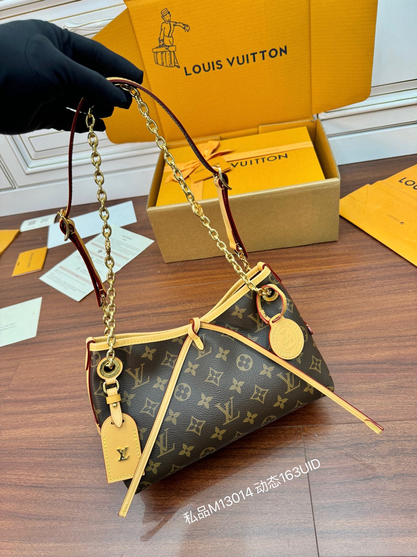 Louis Vuitton monogram shoulder bag held by chain strap, tan handles and leather pull