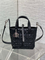 Black Dior mini tote with crossbody strap and front monogram charm