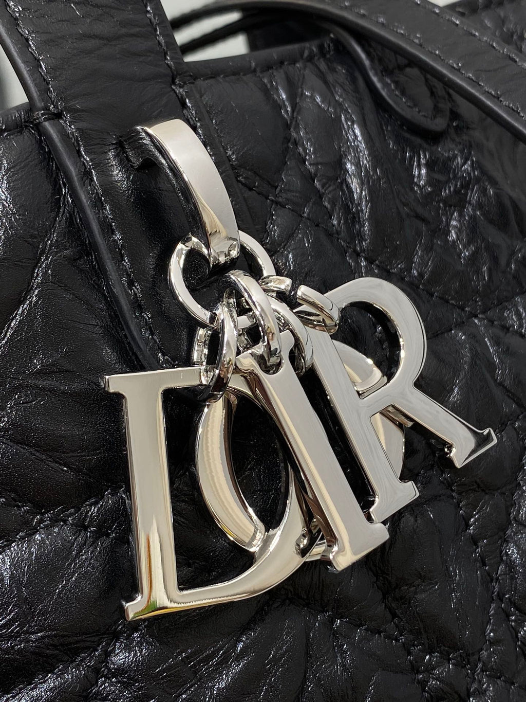 Dior monogram hardware charm with silver rings on black bag