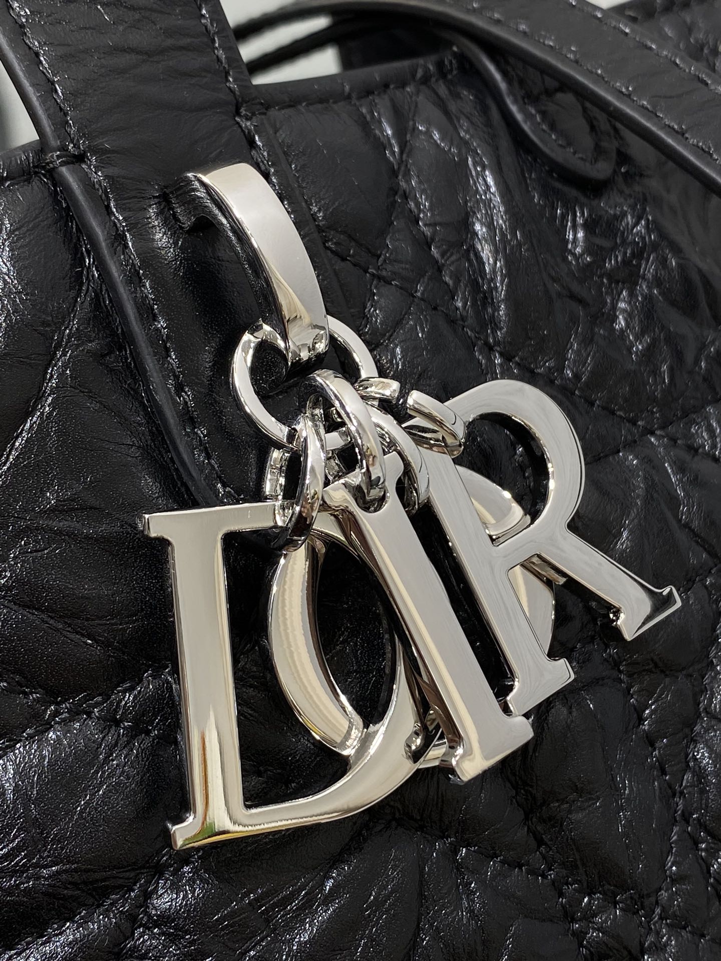 Dior monogram hardware charm with silver rings on black bag