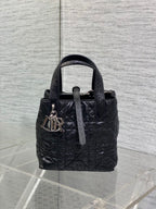 Black Dior mini bag with top handles and front monogram charm