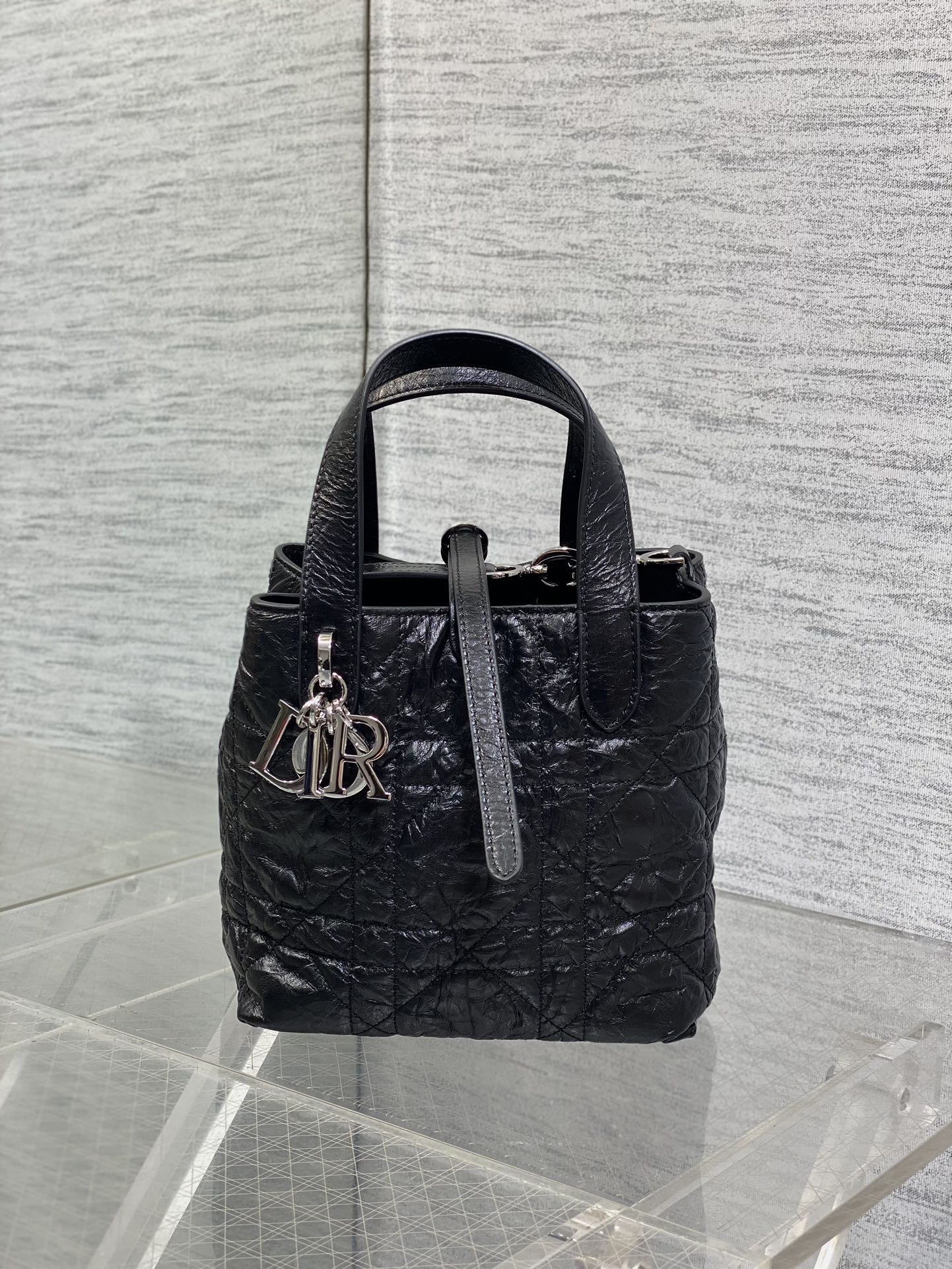 Black Dior mini bag with top handles and front monogram charm
