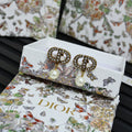 Dior logo stud earrings with crystal halo and white pearl drop