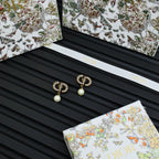 Dior logo drop earrings with crystal border and white pearl drops on card