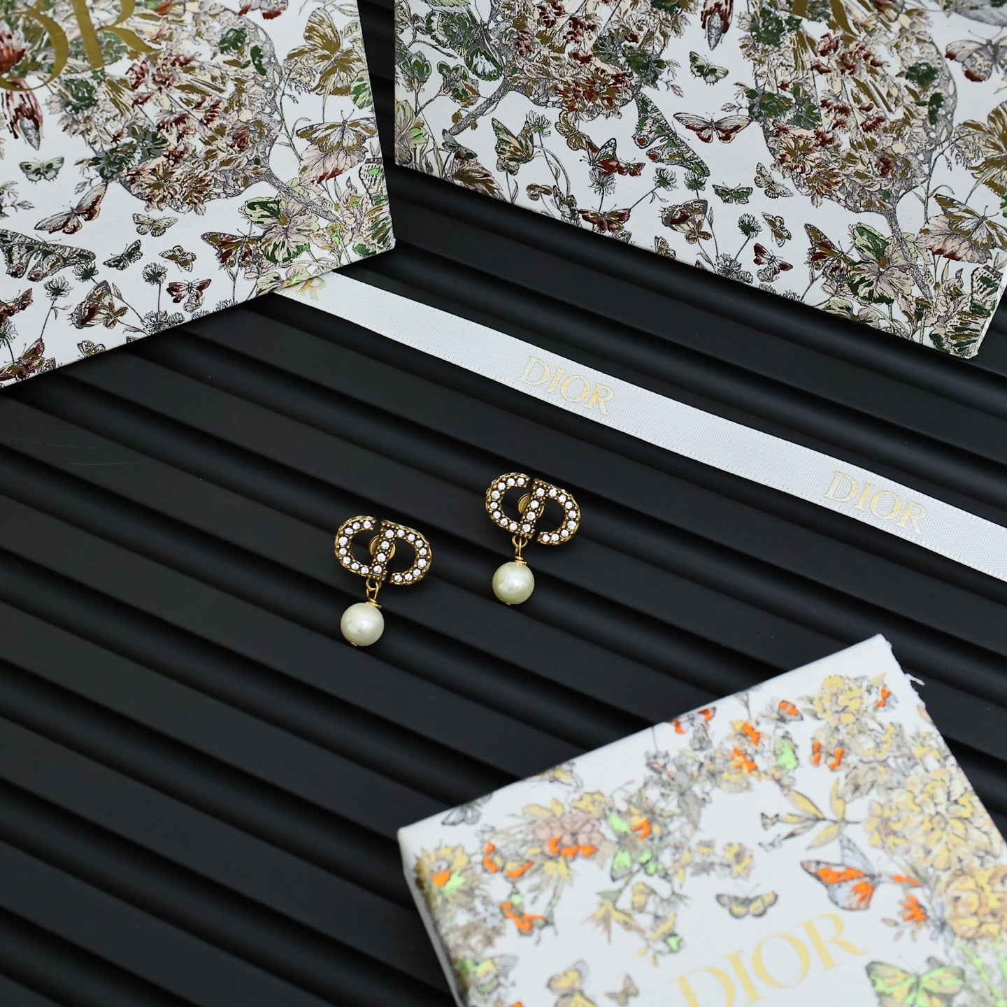 Dior logo drop earrings with crystal border and white pearl drops on card