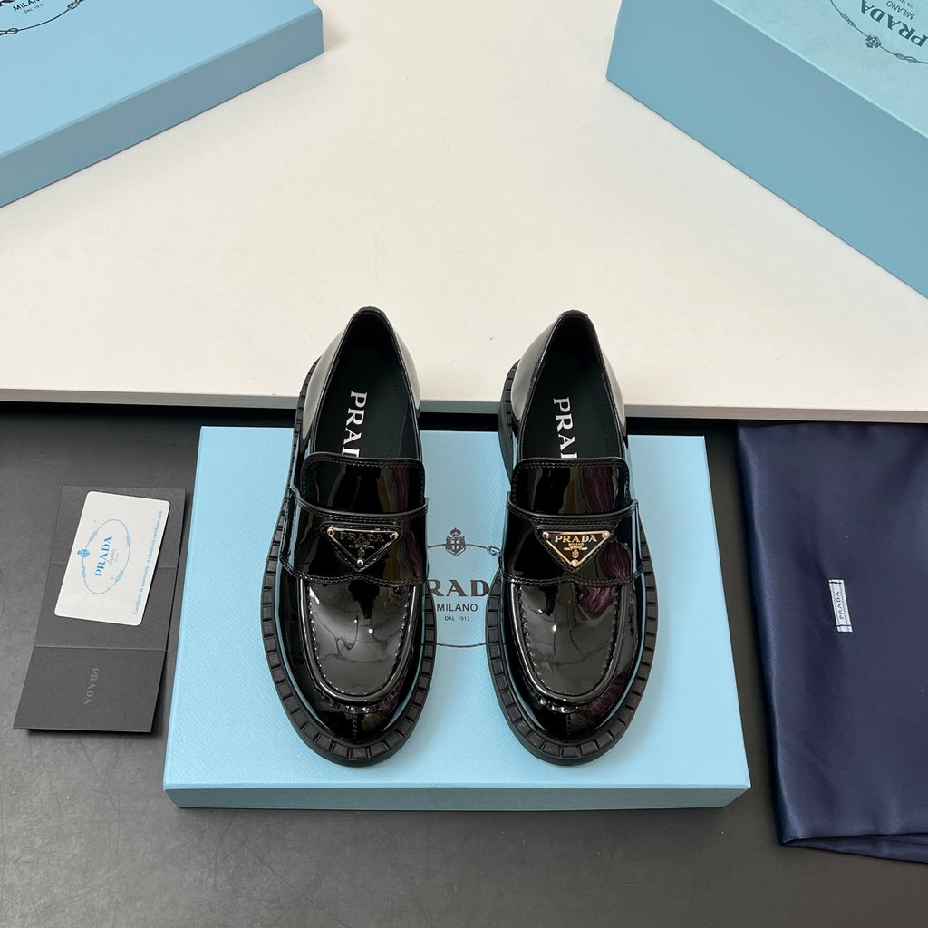 Prada unisex patent loafers in glossy black with decorative strap and chunky sole