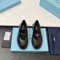 Prada unisex patent loafers in glossy black with decorative strap and chunky sole