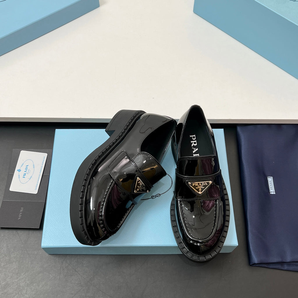 Prada unisex patent loafers in black with burgundy accent and gold triangle emblem
