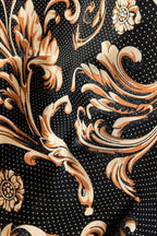 Shirt fabric close-up: black ground with gold-and-orange floral scrolls and tiny dot pattern.