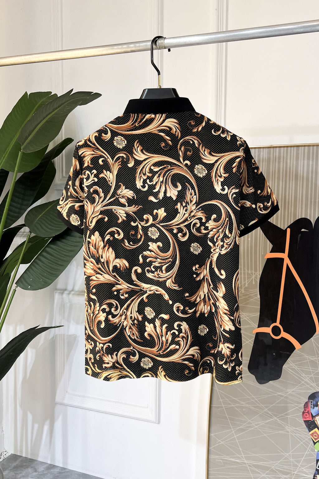 Short-sleeve button-up shirt with baroque paisley pattern on black, gold highlights, collar.