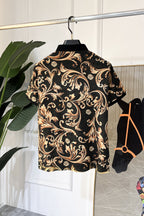 Short-sleeve button-up shirt with baroque paisley pattern on black, gold highlights, collar.