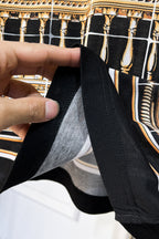 Versace short-sleeve shirt hem close-up, black with white grid lines and gold border print