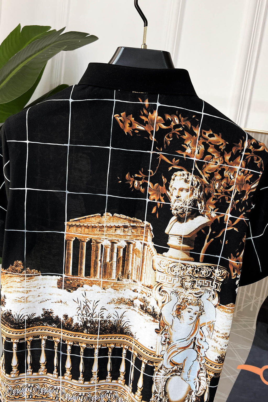 Versace short-sleeve shirt, back view with black ground, white grid lines, gold baroque print