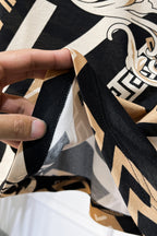Versace shirt fabric seam detail in black, beige, and white with Greek motifs