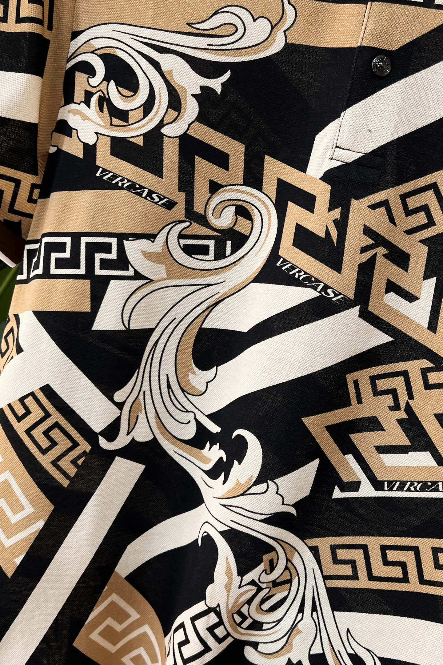 Versace shirt front with ornate gold, black, and white graphic print