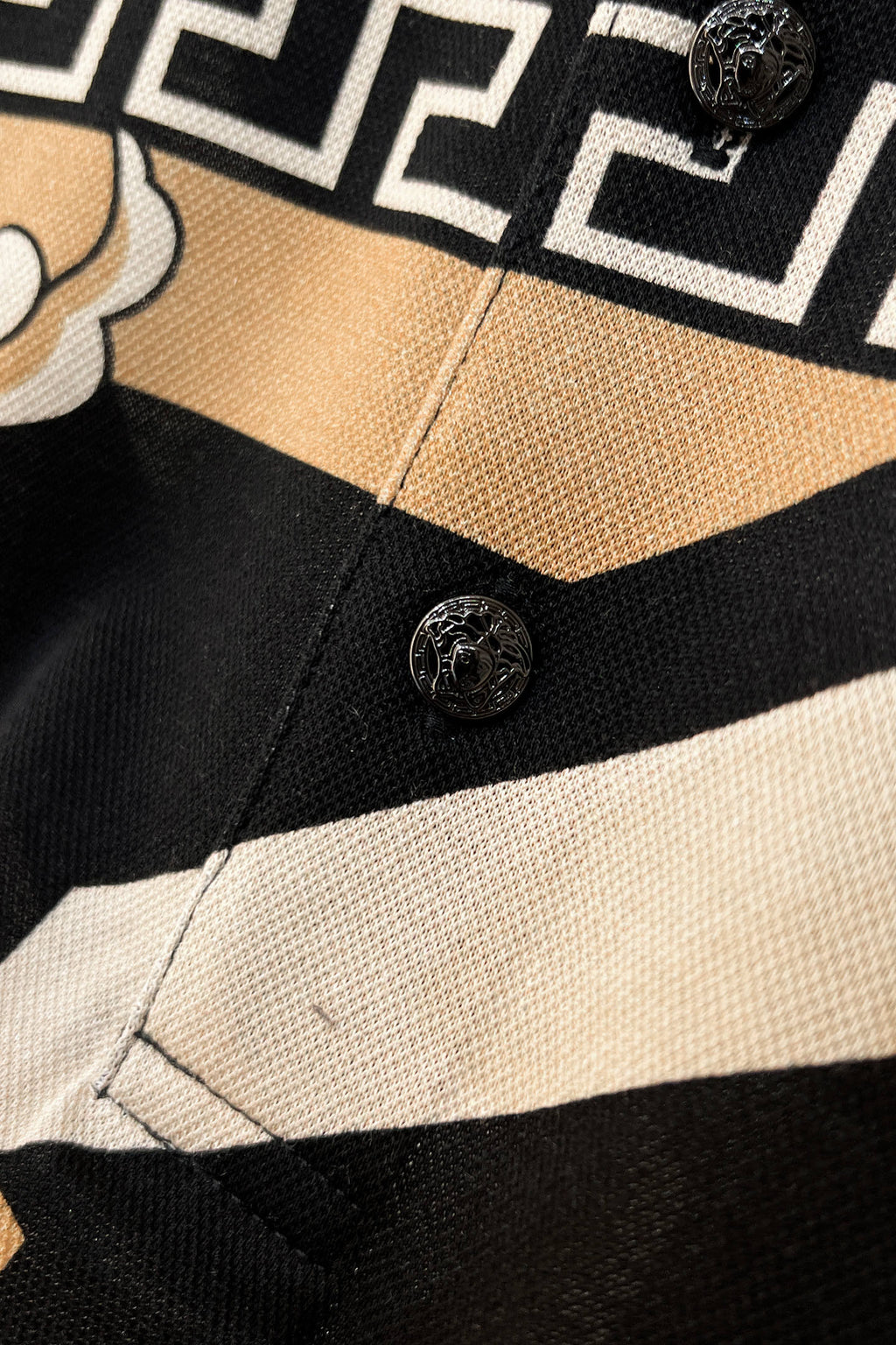 Versace shirt placket with round buttons and black-and-beige striped fabric