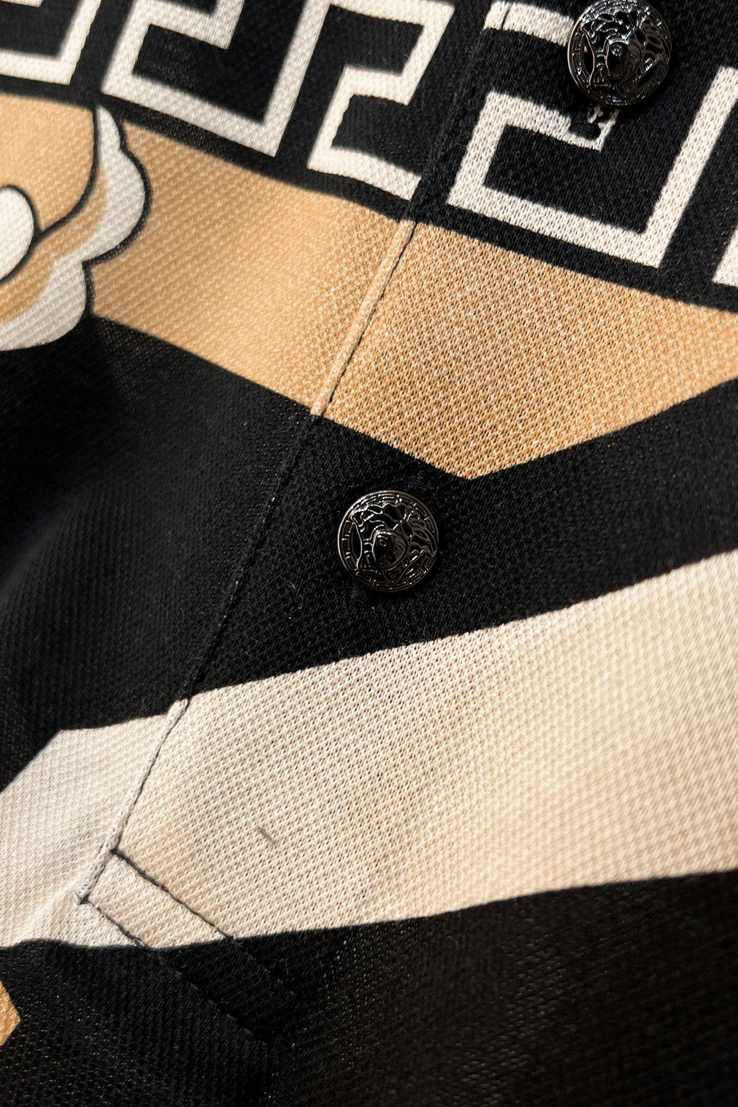 Versace shirt placket with round buttons and black-and-beige striped fabric
