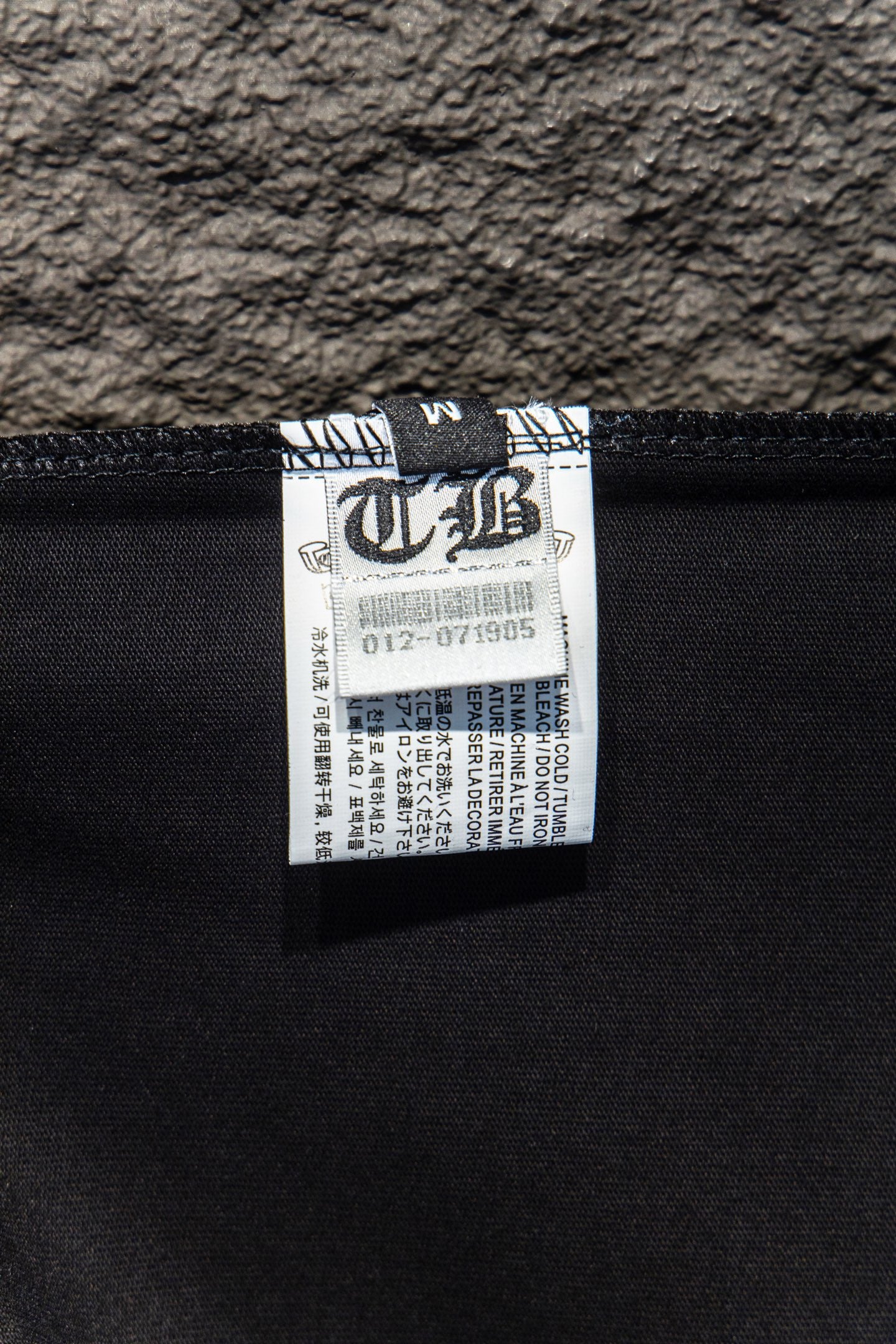 Black T-shirt interior fabric label near neckline seam